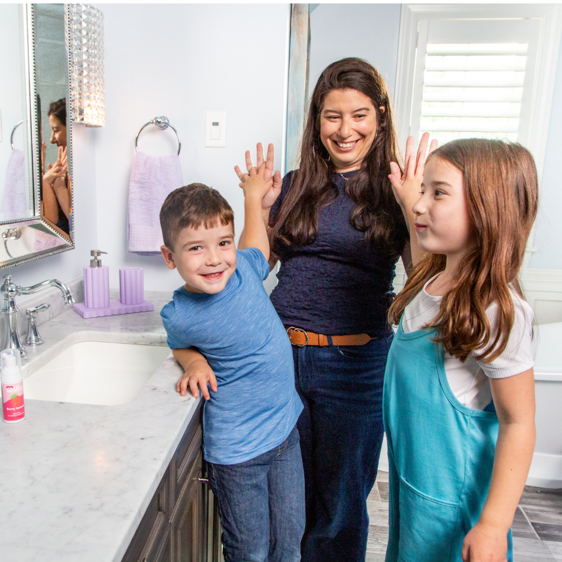 Woman with two children in a bathroom setting, likely discussing dental hygiene.