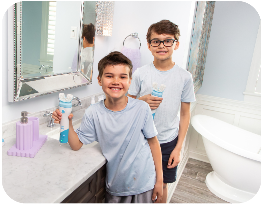 Two boys in a bathroom holding bottles, with a focus on dental hygiene.