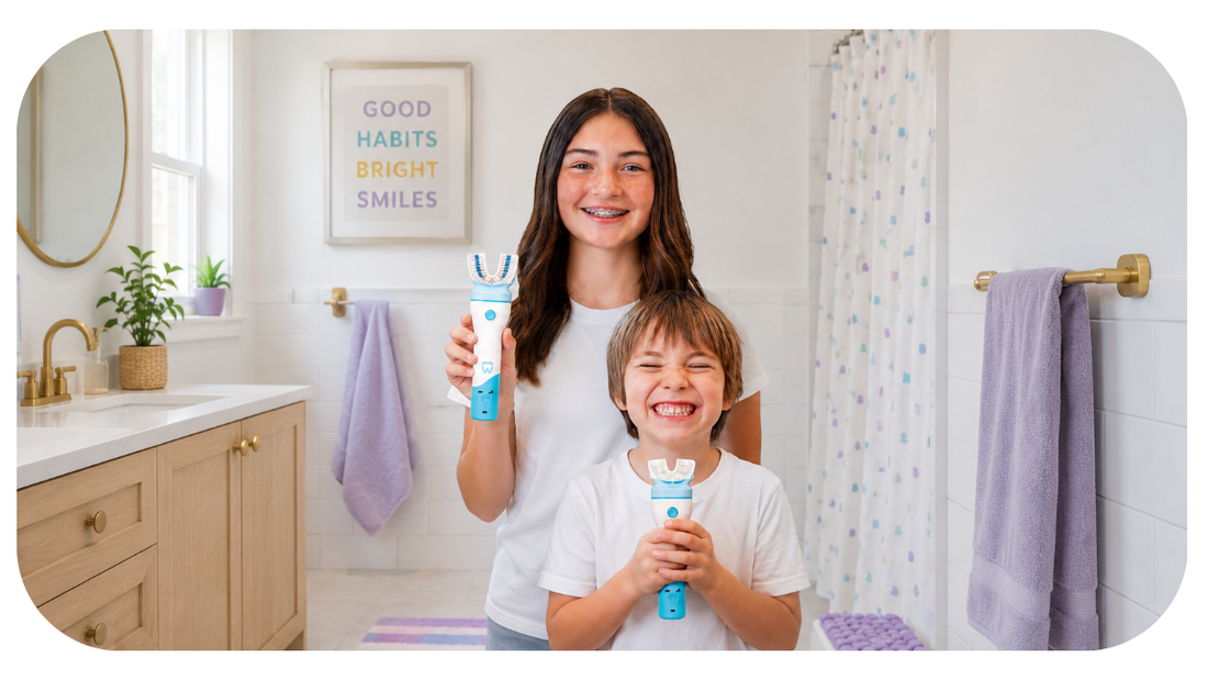 Sister and brother holding willo kids toothbrushes and smiling in a white bathroom with purple towels