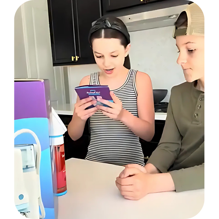 Sibling product unboxing video still featuring a young girl reading the setup manual for the Willo smart toothbrush system next to its product packaging on a kitchen counter.