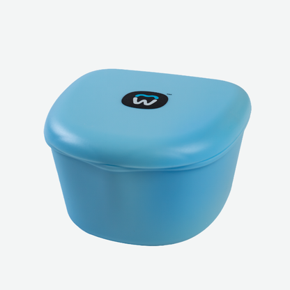 A close-up product shot of the light blue Willo Brush Head Case. The smooth, rounded plastic container is closed, featuring the black and blue Willo tooth logo centered on the top lid against a plain white background.