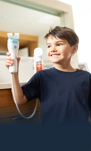 Child holding a Willo kids toothbrush in a bathroo