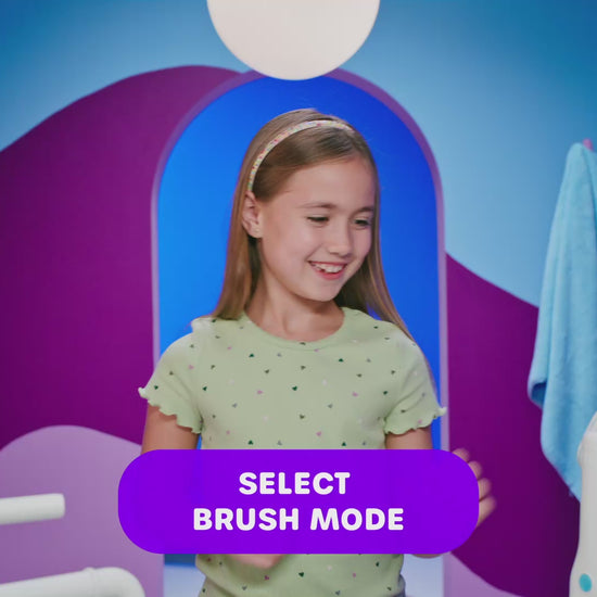 8 year old girl showing how to use AutoFlo+ to brush teeth